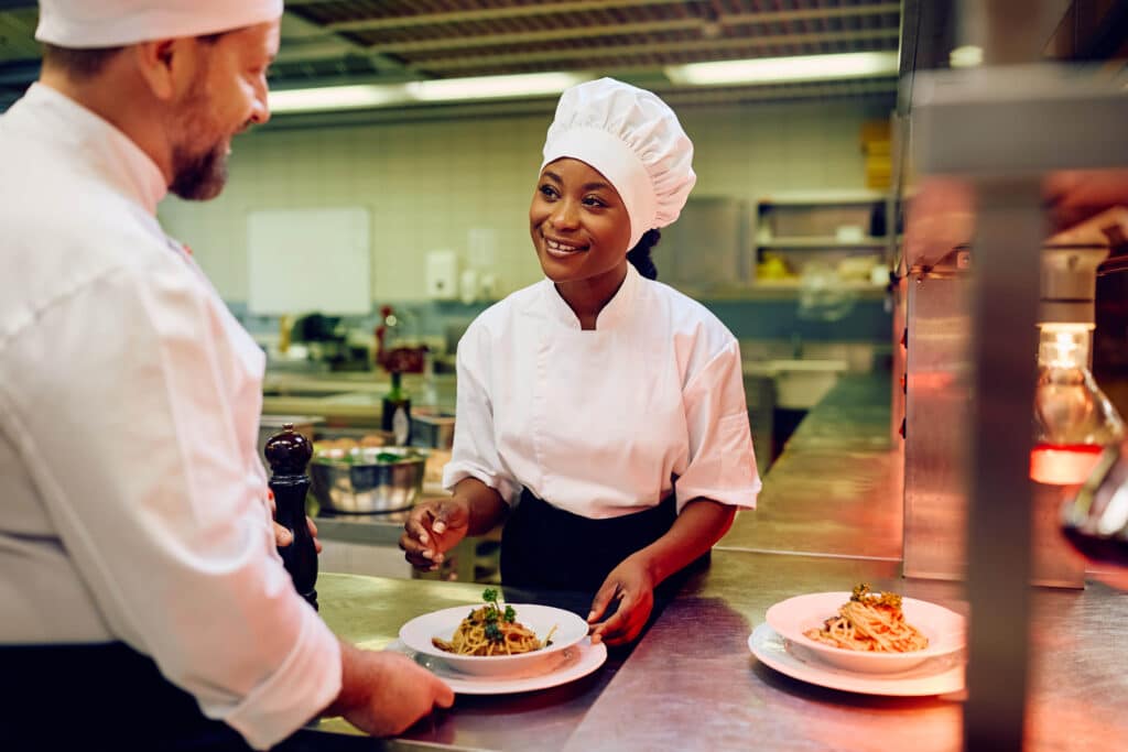 Mala Barad smiling and collaborating with a colleague in the kitchen